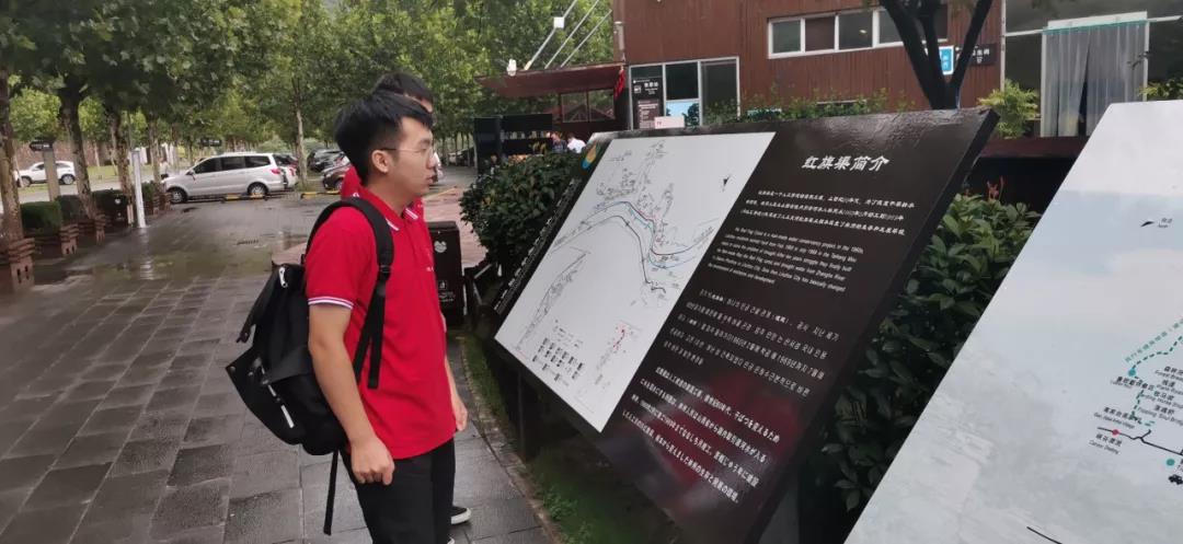 实践队员在红旗渠简介前伫立着，认真阅读红旗渠过去的峥嵘岁月.jpg