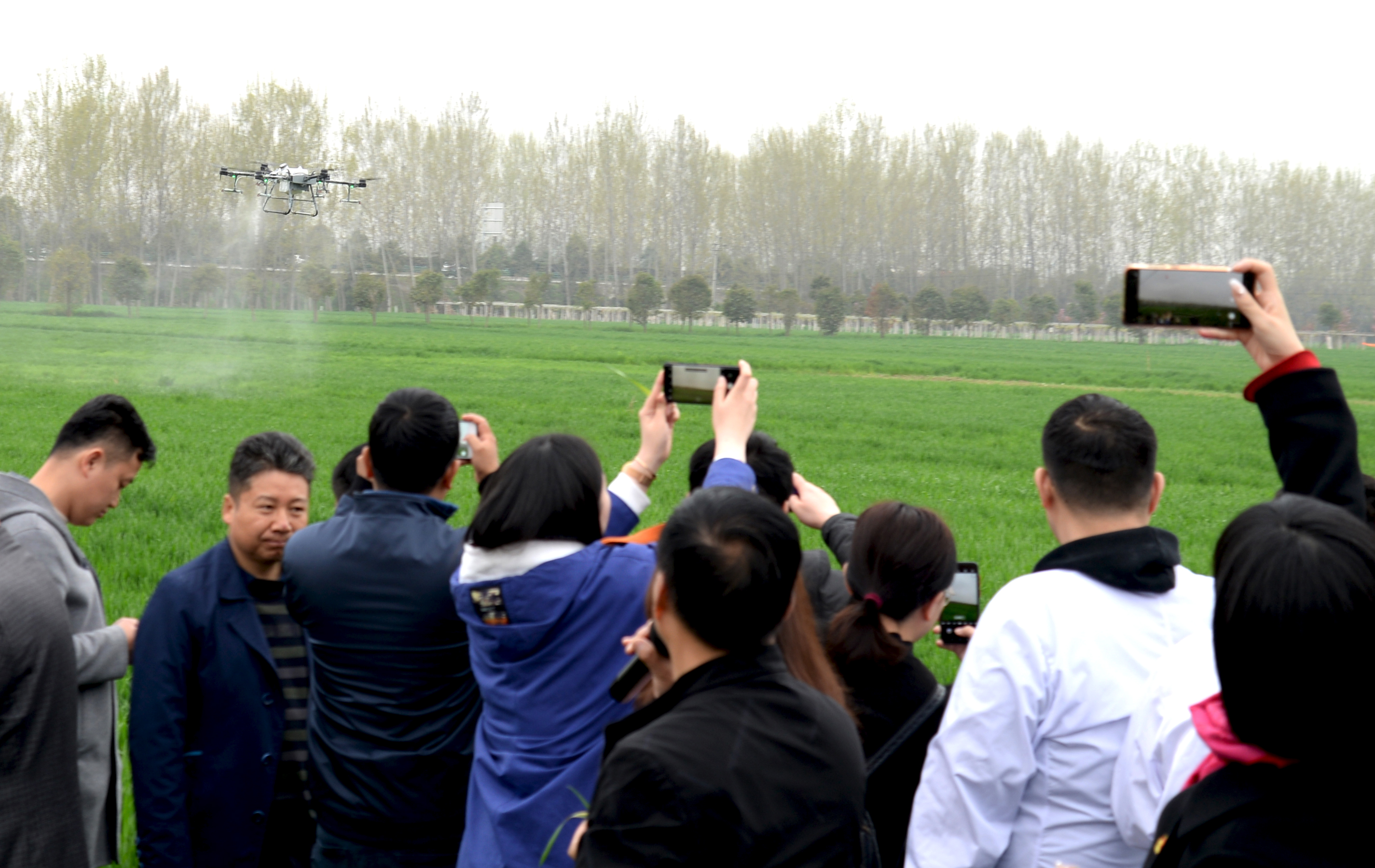 7师生们在观看无人机喷药防治小麦条锈病.jpg