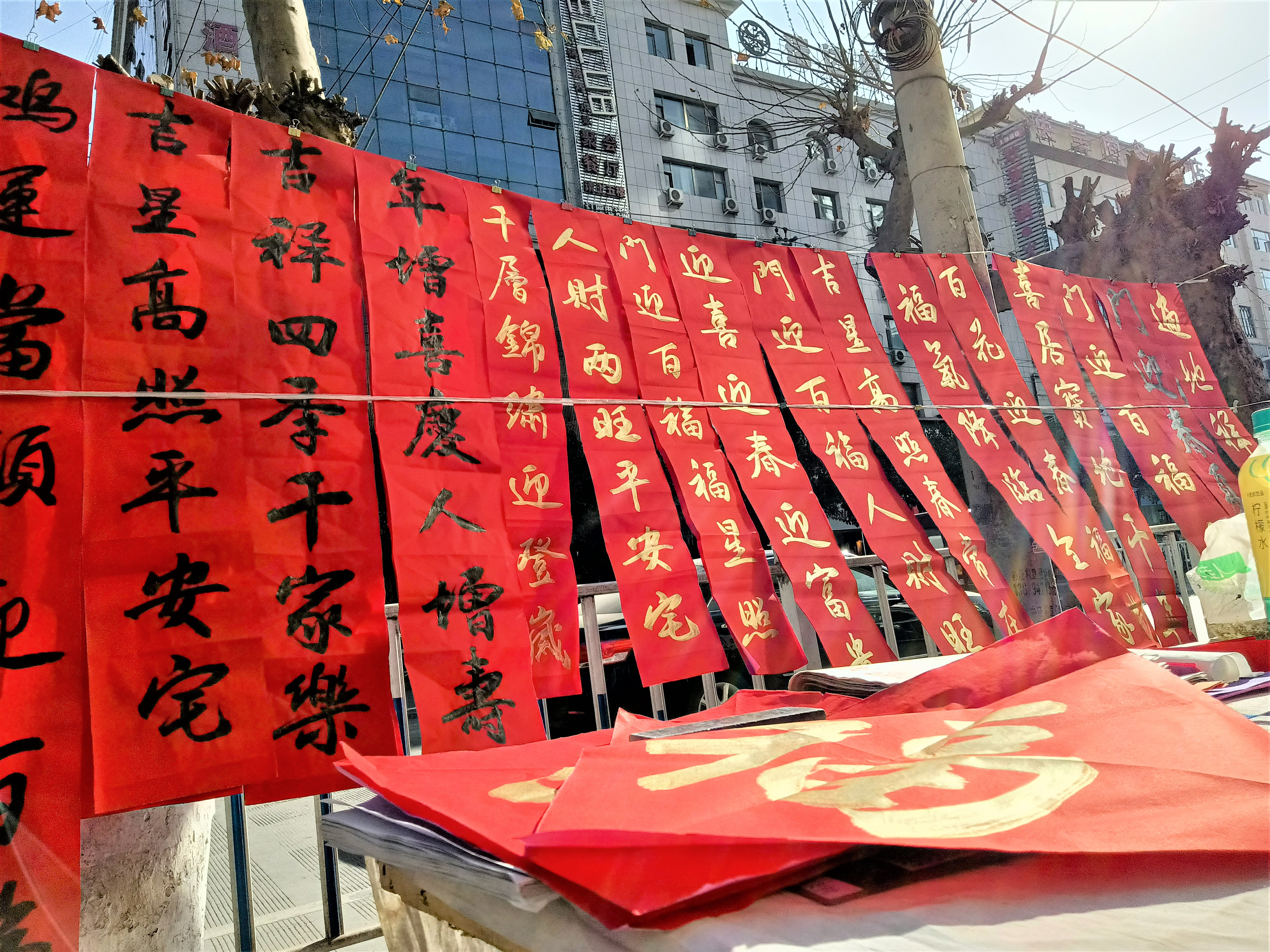 年关将至，年味正浓。街道上挂起了一幅幅写好的对联，上面承载着满满的新年祝福和幸福安康。微风轻佛，红纸翻飞，沙沙作响，给这座小城又增添了几份节日的喜庆。