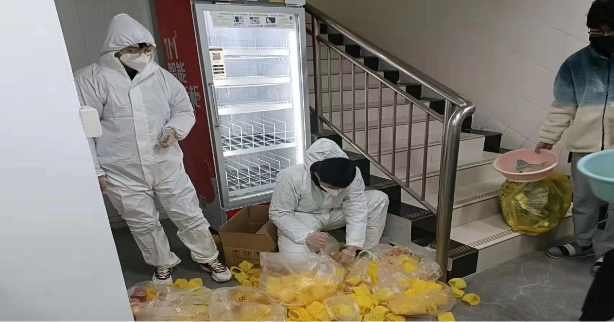 图2 东四学生社区疫情楼栋封控期间党员志愿者分发物资.png