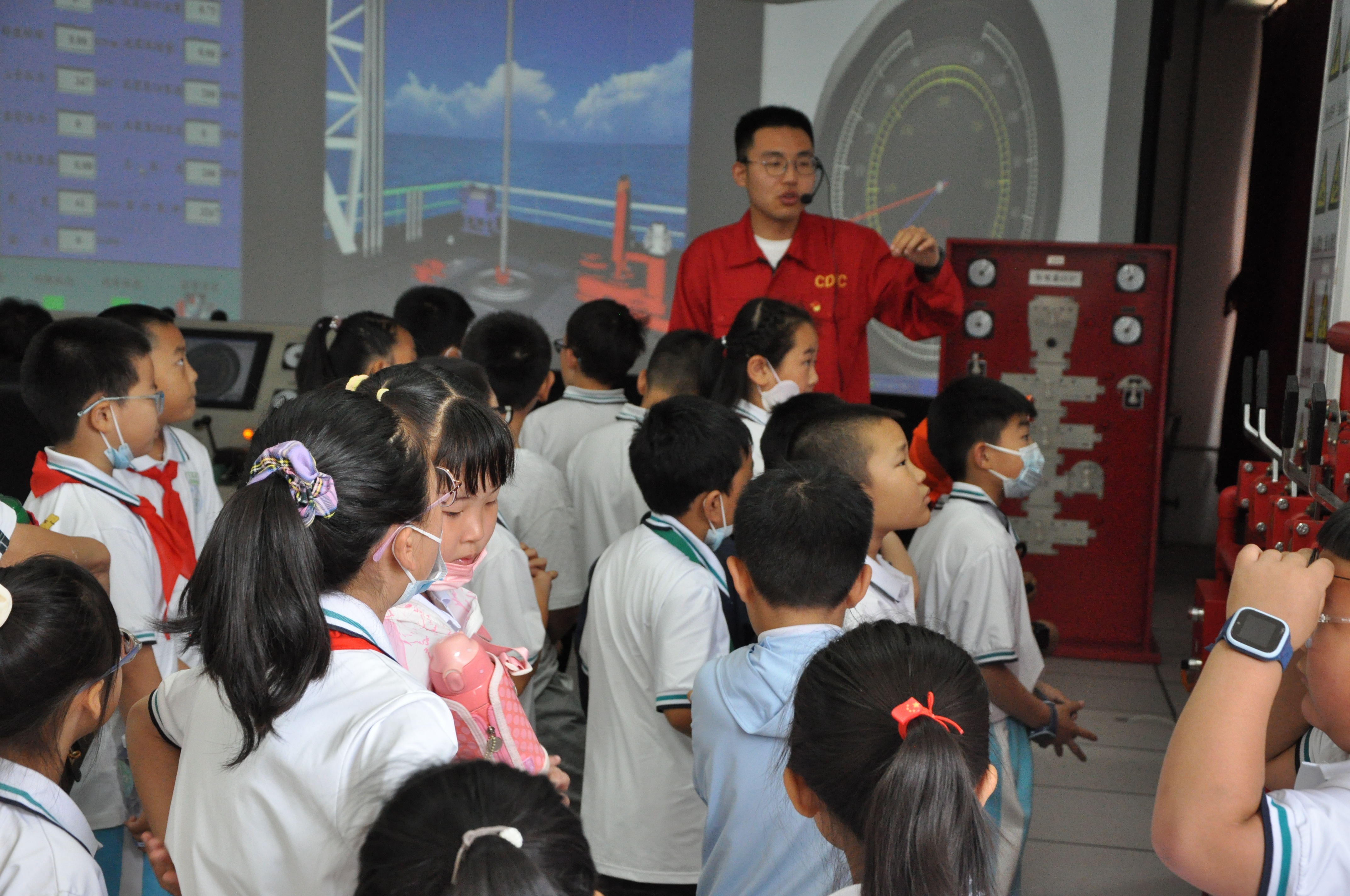 志愿者利用钻井仿真实训室为小朋友们讲解钻井过程。
