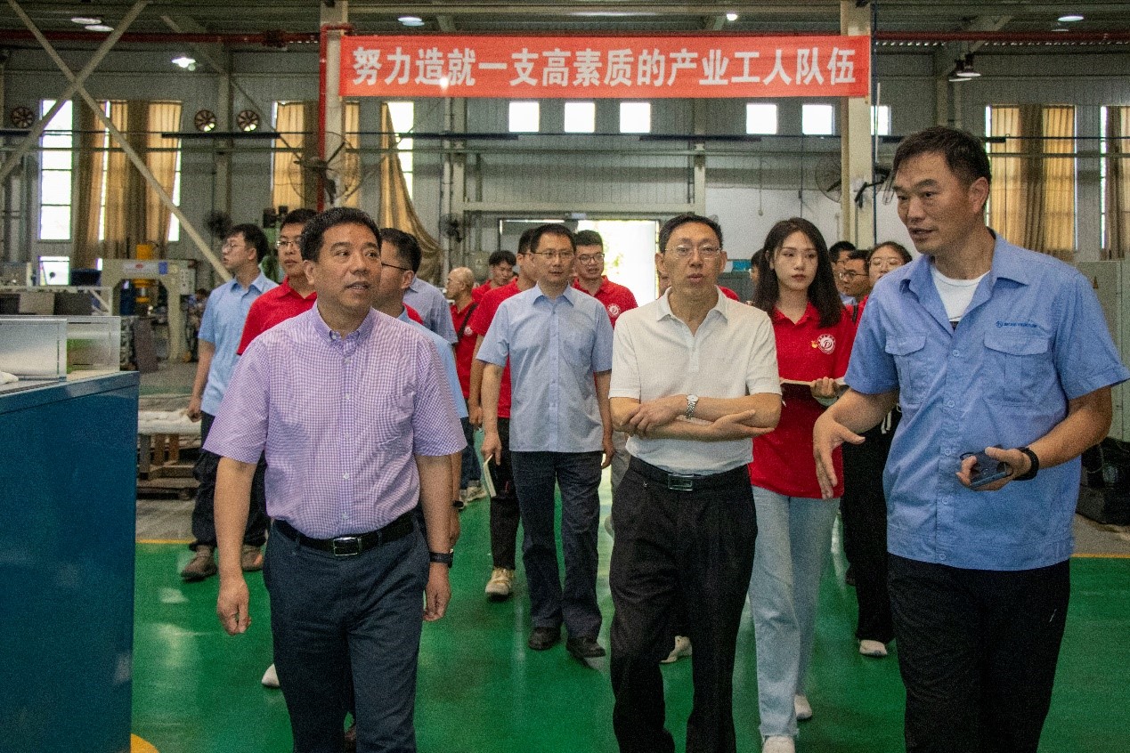 图为王国春书记带领实践队员们参观生产车间。.jpg