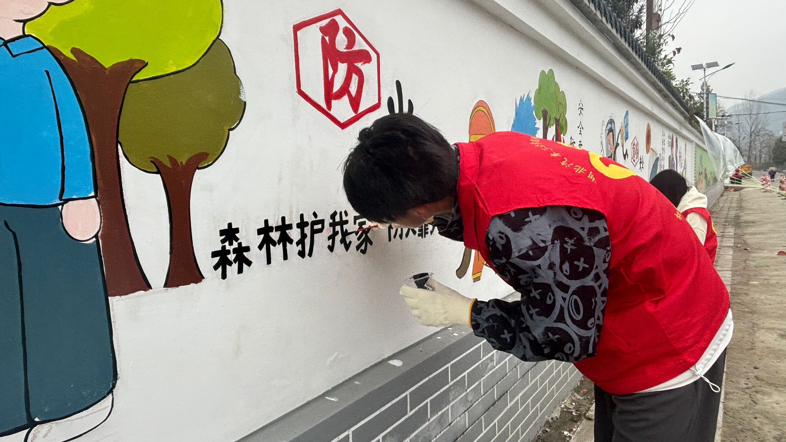 2023.11.13房县土城村墙绘小组组员认真创作.jpg