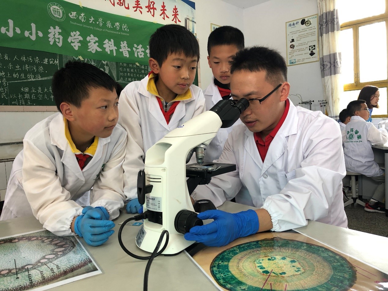 图1 支部尹国平老师正在指导黄水小学学生观察中药材切片.jpg 图1 支部尹国平老师正在指导黄水小学学生观察中药材切片.jpg