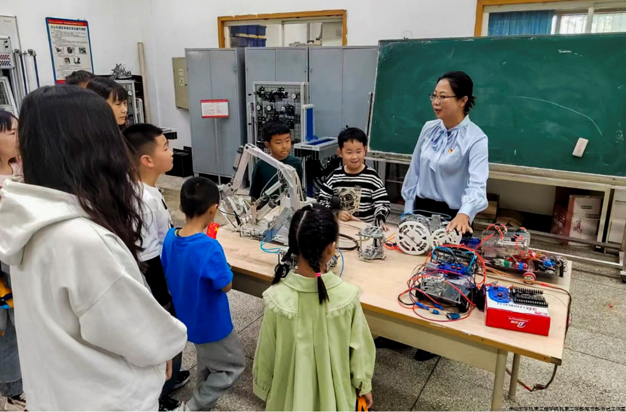 姚静教授为参观者介绍智能气动行走小车.png 姚静教授为参观者介绍智能气动行走小车.png