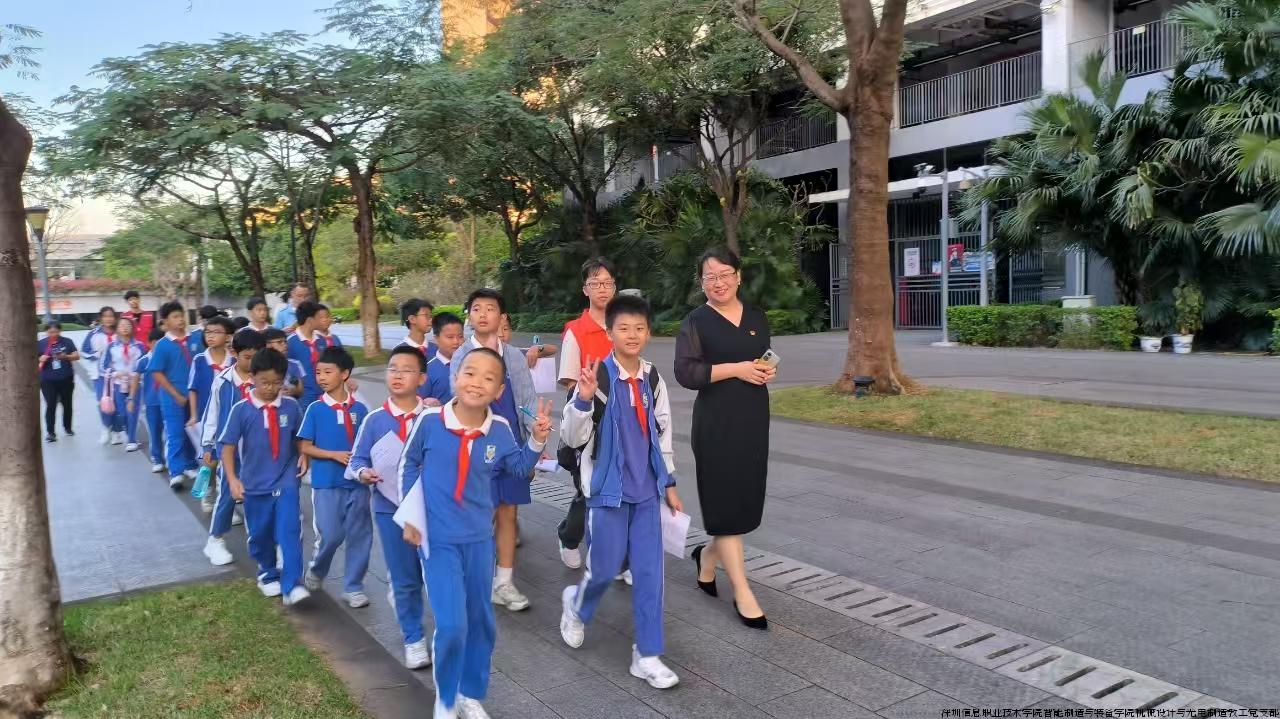 华附大运学校师生在党支部书记徐晓梅带领下，一路走一路了解深圳信息职业技术学院的校园设施和校园文化